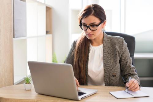 front-view-businesswoman-working-laptop-office